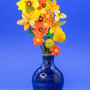 Blue ceramic vase with orange and yellow flowers. Vase is 2-inces tall, overall piece is 5-inches tall.