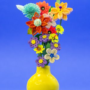 Yellow ceramic vase of quilled and punched flowers.