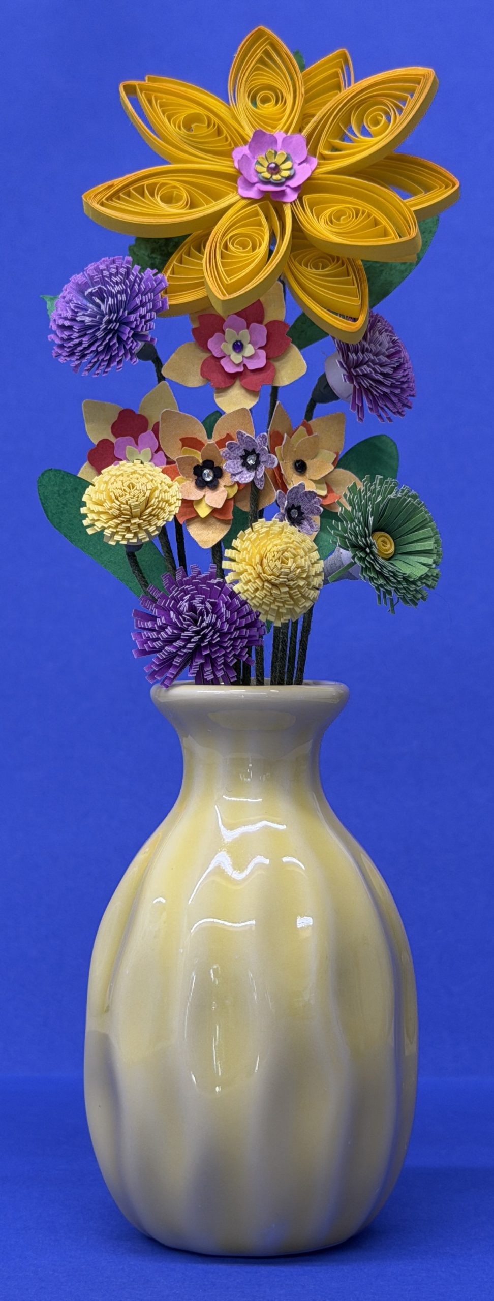Yellow ceramic vase with purple, green and yellow flowers