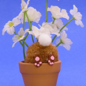 This cute bunny is digging in the terra cotta flowerpot with white flowers and all you can see is his behind. The overall size is 4x3".
