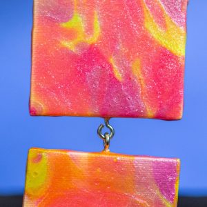 These 2.75x2.75 canvases were created with a "paint pour" method. I've joined 2 together and added a string to hang them from for a total length of 9".